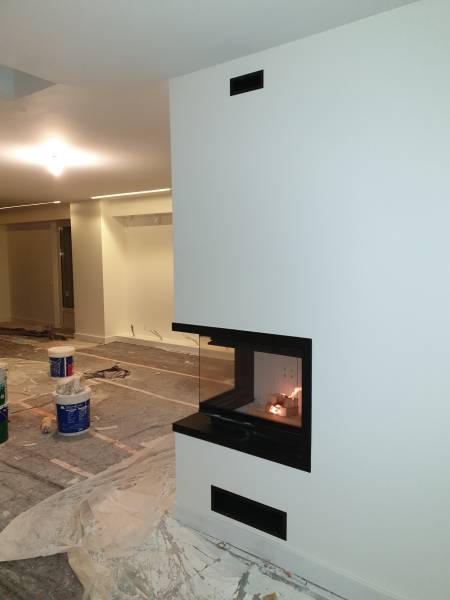 Installation design d’un foyer bois d’angle à vitre relevable BRANSTAL à Montpellier pour un chauffage performant et esthétique